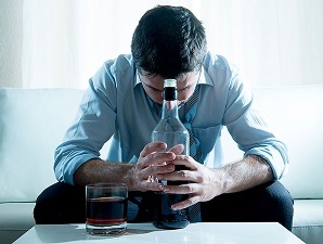 Businessman wearing blue shirt drunk at desk on white background